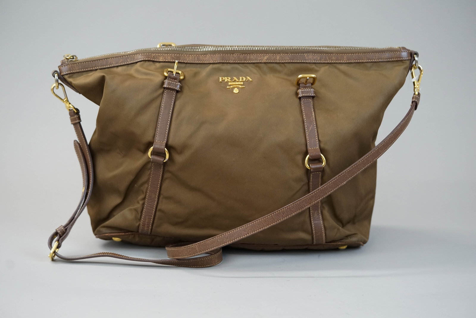 PRADA BROWN NYLONE BAG: PRADA BROWN NYLONE BAG DIMENSIONS: Width 34cm, height 28cm, depth 14cm COLOUR: Brown MATERIAL: Nylon leather trim ACCESSORIES: n/a CONDITION RANK:BC If you have any questions regarding this lot