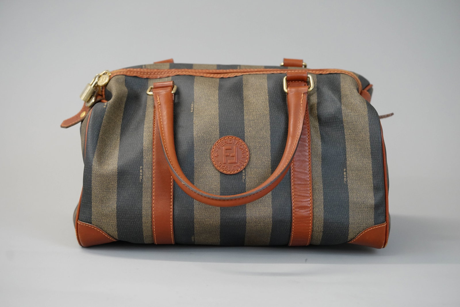 FENDI HOLDALL BAG: FENDI HOLDALL BAG DIMENSIONS: Width 34cm, height 18cm, depth 18cm COLOUR: Brown MATERIAL: Coated canvas ACCESSORIES: n/a CONDITION RANK:B If you have any questions regarding this lot please contact