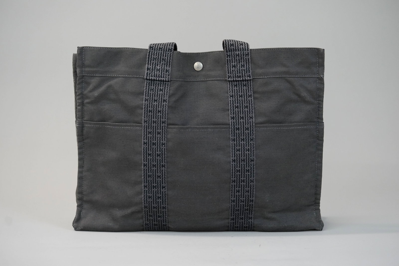 HERMES TOTE BAG: HERMES TOTE BAG DIMENSIONS: Width 43cm, height 32cm, depth 10cm COLOUR: Dark grey MATERIAL: Canvas ACCESSORIES: n/a CONDITION RANK:B If you have any questions regarding this lot please contact us. For