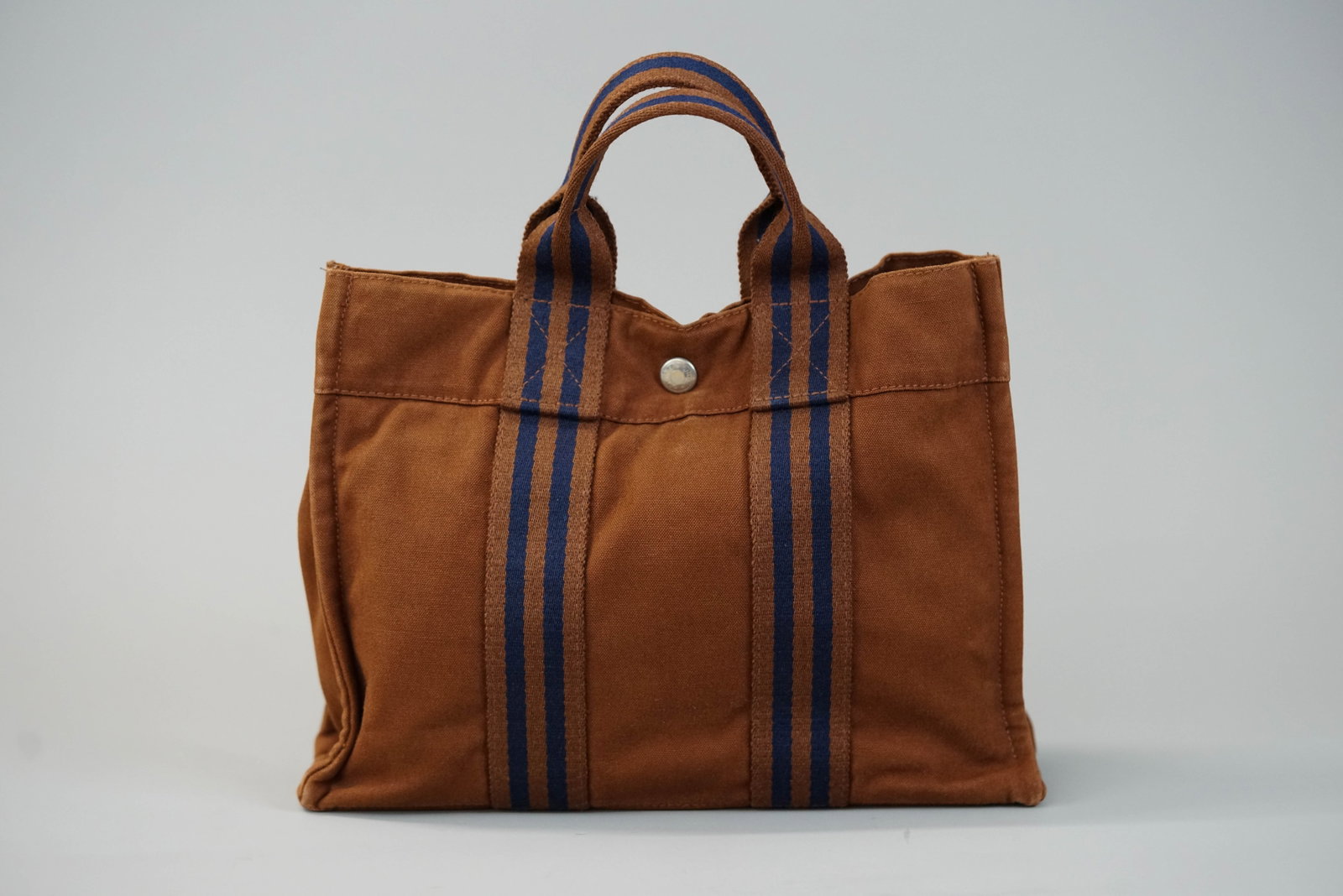 HERMES CANVAS HANDBAG: HERMES CANVAS HANDBAG DIMENSIONS: Width 28cm, height 22cm, depth 8cm COLOUR: Brown and blue MATERIAL: Canvas ACCESSORIES: n/a CONDITION RANK:BC If you have any questions regarding this lot please