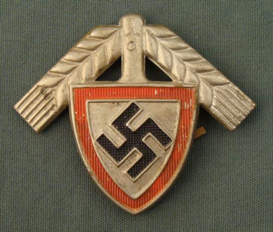 NAZI REICH ARBEIT DIENST/RAD ORIG VISOR CAP INSIGNIA: THIS IS A WELL PRESERVED NAZI REICH ARBEIT DIENST/RAD VISOR HAT INSIGNIA. THE INSIGNIA IS AN ORIGINAL PERIOD ITEM. IT HAS THE SHOVEL/SPADE WITH A RED OUTLINE AND BLACK SWAST