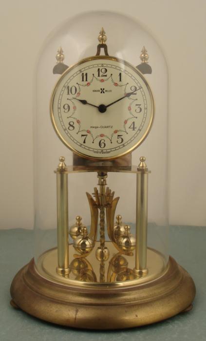 Howard Miller Anniversary Shelf Mantle Clock Germany: This is a Howard Miller anniversary clock, with quartz movement made in Germany. We don't know if it is running, as it needs a C size battery. Its physical condition is very good, however, with just s