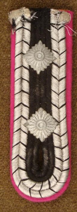WWII Nazi Officers Panzer Tank Collar Epaulet Magenta: This is a WWI era Nazi Collar Epaulet from a Hauptfeldwebel, the most senior sergeant of the time. It is magenta felt, with black and silver threading, and two metal fittings. The size is 1 1/2" x 4 1