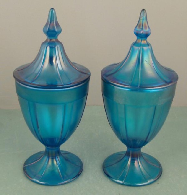 Pair Vintage Blue Carnival Glass Apothecary Jars: These two vintage carnival glass Apothecary Jars are teal blue, with a nice luster that really shows up in the light. Overall they stand about 9 1/2" tall to the tops of their pointy lids, and 4" wide