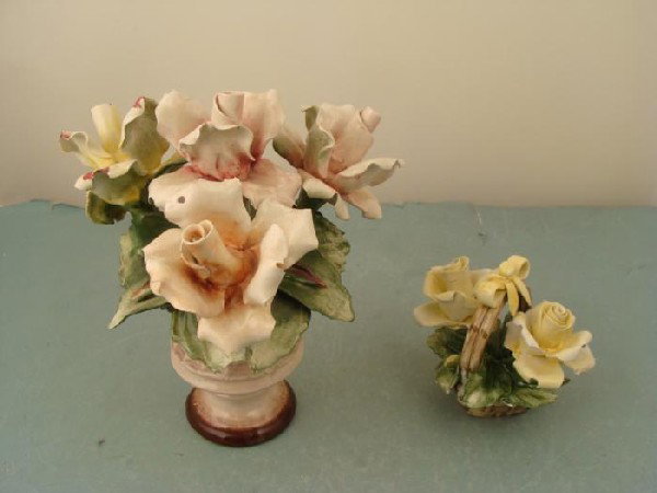 2 Capodimonte Vintage Porcelain Flowers Italy: Here are 2 pretty Capodimonte flowers from Italy. Both have foil stickers and stamps. One is yellow and pink in a woven style vase, 8" tall. The other is a yellow, in a little handled basket, 4" tall.