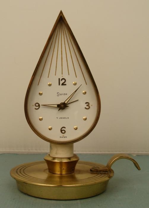 Swiza Mid Century Modern Vintage Swiss Candle Clock: This alarm clock is in the shape of a little candle flame, and it rests on a short candle on a candle holder. The maker is Swiss, called Swiza, and created this fine design around the 1950's. The 7 je