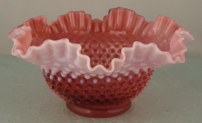 Cranberry Milk Glass Vintage Candy Dish Bowl: This glass candy dish is milk glass in a mostly cranberry tone, with white portion at the crimped rim. It dates back over 40 years. The size is 9" in diameter, and 4 1/2" tall. Its condition is excell