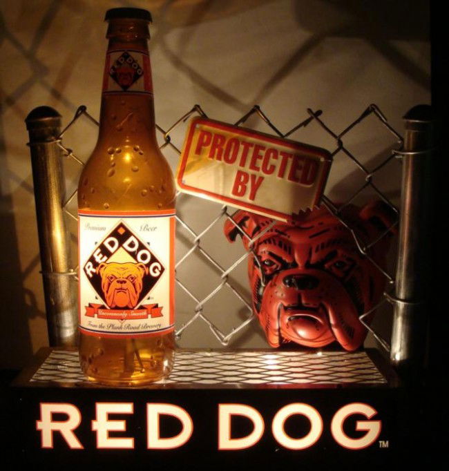 HUGE RED DOG BEER BAR TOP ADVERTISING SIGN: HUGE "RED DOG BEER" BAR TOP ADVERTISING DISPLAY-ELECTRIC- IN WORKING CONDITION. -A MENACING RED DOG PEERS FROM BEHIND THE REAL CHAIN LINK FENCE. WHILE A BIG PLASTIC BEER BOTTLE STANDS AT THE SIDE. LIG