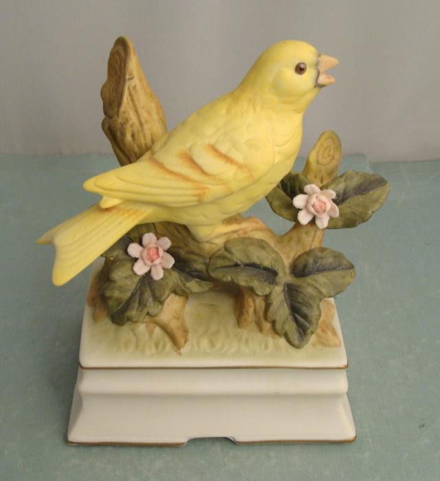 Yellow Bird Towle Porcelain Music Box Figurine: This little yellow bird porcelain figurine looks like its singing a song, and it does when you wind up the music box at the base. This was created by Towle of fine porcelain, with nice details. Its si
