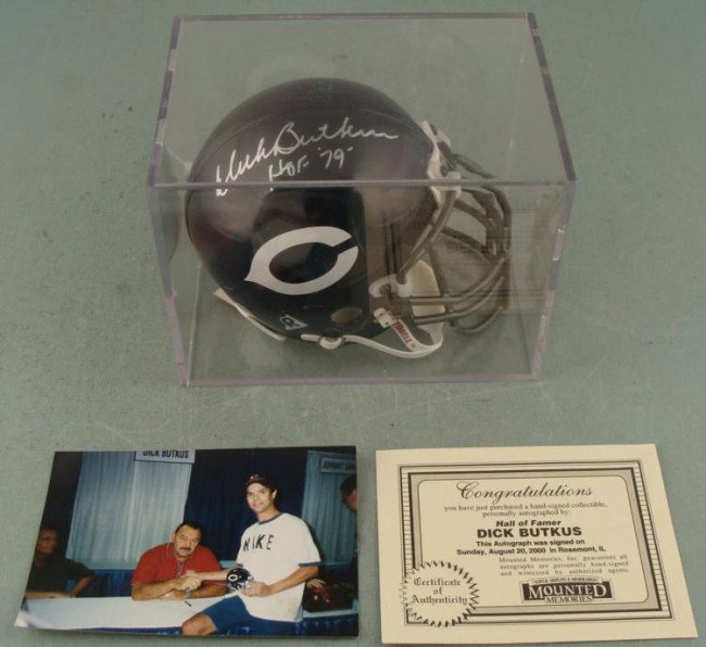 Dick Butkus Signed Bears Mini Helmet -Display COA Photo: This mini helmet was signed in silver paint pen by Bears great Dick Butkus, along with his Hall of Fame year '79. The helmet is a Riddell size 3 5/8. It comes in an acyrlic display, 5 1/2 x 7 