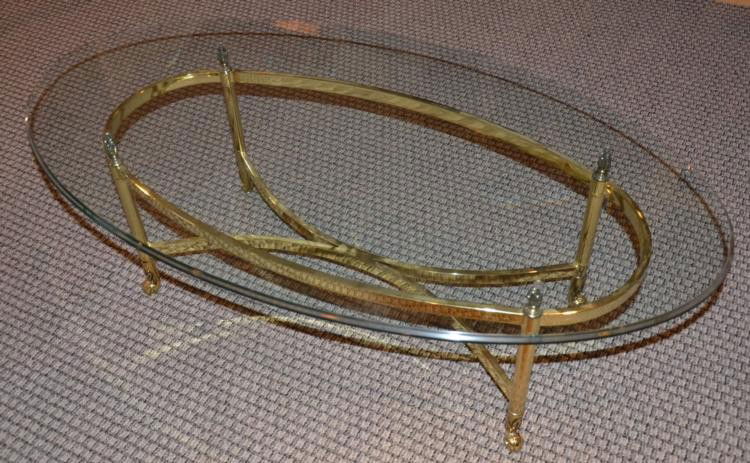 Brass & Glass Top Oval Coffee Table 28 x 49 Inches: This is an oval shaped coffee table with brass frame, and glass top. The frame dimensions are: 15 1/2" high and 18" x 40". The glass dimensions are 28" x 49 1/2". It is in very good condition, with no
