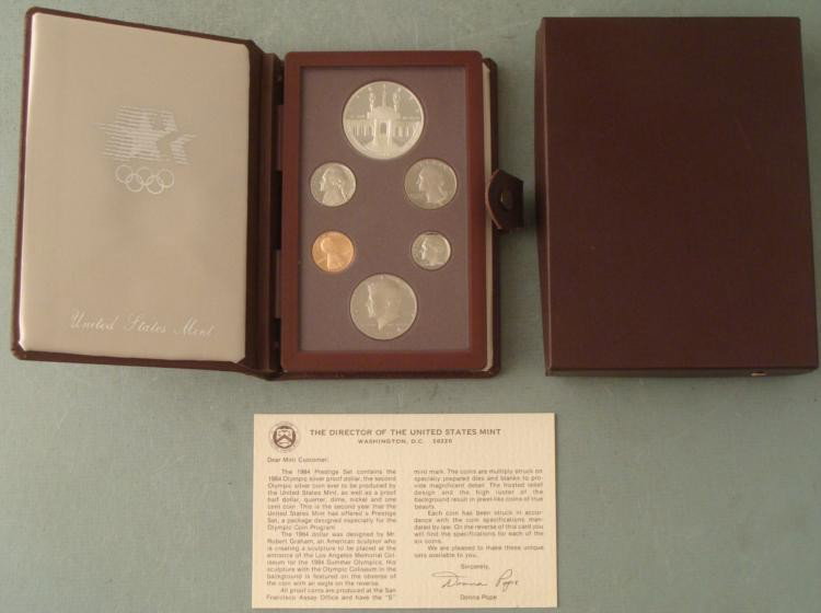 1984 US Mint Olympic Prestige Set w/Silver Dollar, COA: 1984 US Mint Olympic Prestige Set * Includes: 6 coins, including 1 silver dollar commemorating the XXIII Olympiad; in fold-open display case, with Certificate of Authenticity from the U.S. Mint Condit