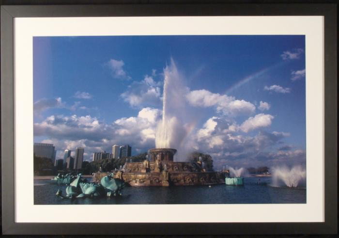 Buckingham Fountain Chicago Framed Photograph: This photograph shows Buckingham Fountain in Chicago, with winds catching the water spray into the clouds above. * Image size: 17 x 27 1/2 inches Framing: Matted in white, in matte black painted wood 