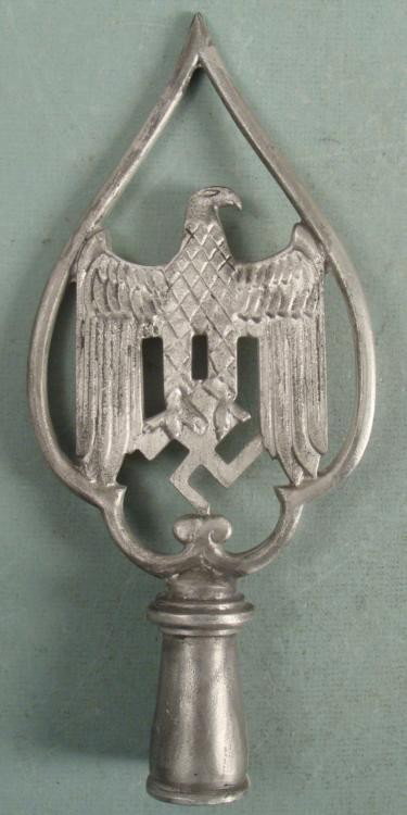 Nazi Eagle & Swastika Flag Pole Parade Topper -Repro: This is a fine quality reproduction of a Nazi flag pole topper. These were used in parades on top of a pole or flag pole. The design features an eagle and swastika, in a pewter tone metal. The size is