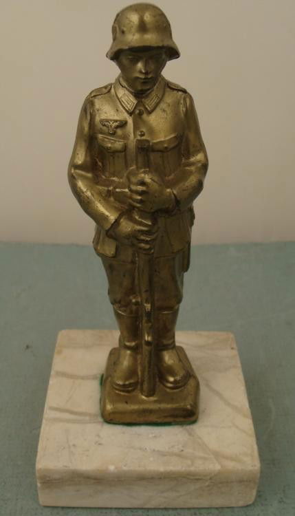 Rare WWII Nazi German Soldier Statue Metal on Marble: This is a rare WWII era find-- a statue of a Nazi soldier holding a rifle. It is brass tone plated metal, affixed to a white marble base. Its condition is very good, with some surface wear in spots. T