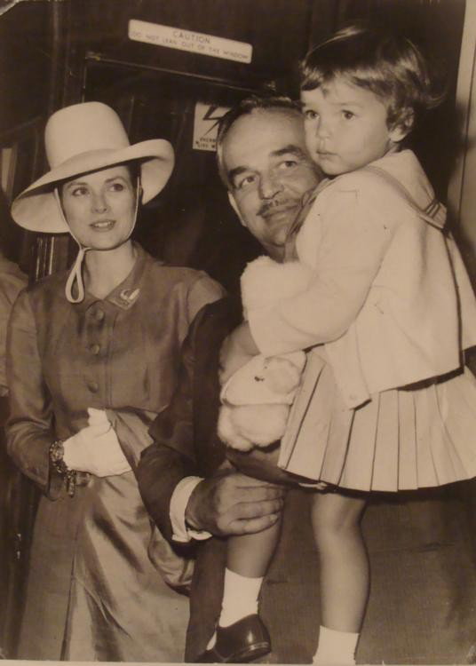 Princess Grace Original Press Photo by Robert Cohen: This is an original British press photo of Princess Grace, with Rainier III, Prince of Monaco, and their daughter, Princess Stephanie. The location is unknown, although it appears to be on a passenger