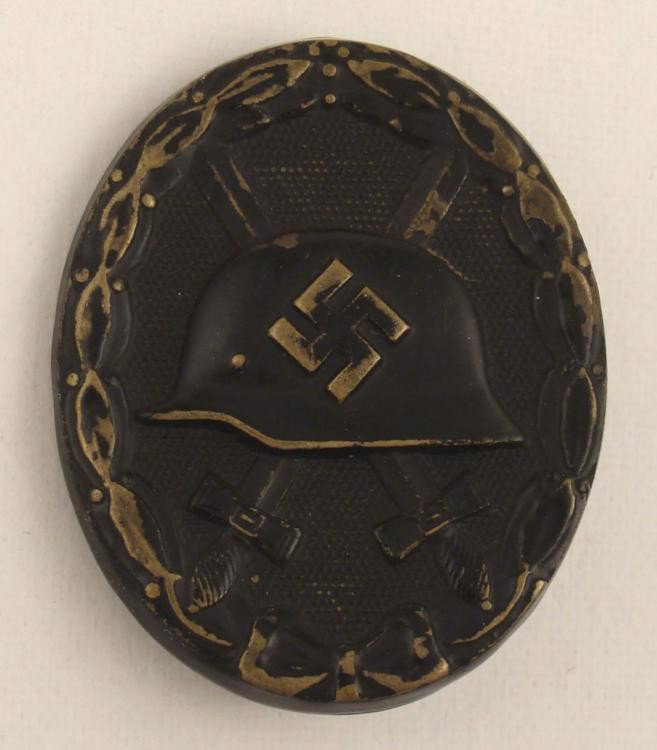 WWII Nazi Wound Badge Pin Original: Here is an original WWII era Nazi wound badge. It is black metal, and has the traditional wound badge design with helmet and crossed swords on dotted background. The size is 1 1/2" x 1 3/4". The mark 