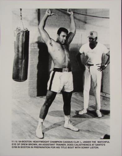 Muhammad Ali Cassius Clay Sonny Liston Boxing Photo: Muhammad Ali, then Cassius Clay, prepares for his big Sonny Liston fight with trainer Drew Brown, as shown in this great behind the scenes photo. The 11" x 14" B & W photo is in excellent conditio