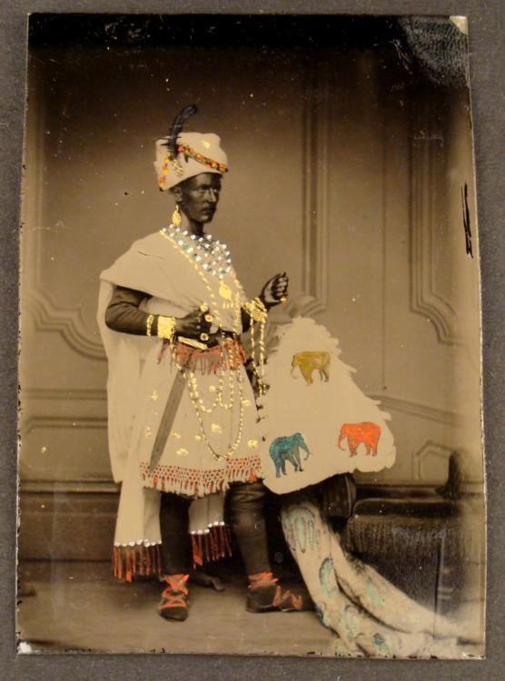 Antique Tintype Photo Indian Man Painted -Rare: This antique tintype photograph depicts a man, apparently from India, in traditional dress. It is elaborately hand-embellished with gold, pink, and blue paint, depicting jewelry and elephants. The pho