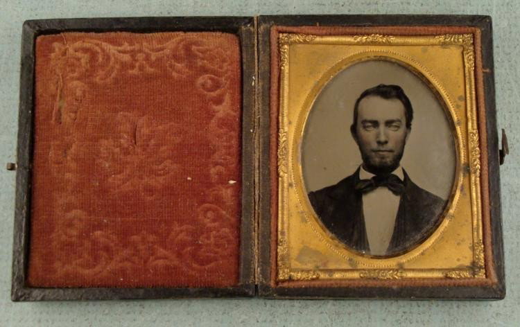 Antique Daguerreotype Photo in Star of David Frame: This is an early photographic portrait of a man is in a hinged case, with Shield of David, flags and eagle on front. There is an embossed double layer gold tone matte, and maroon patterned velvet lini