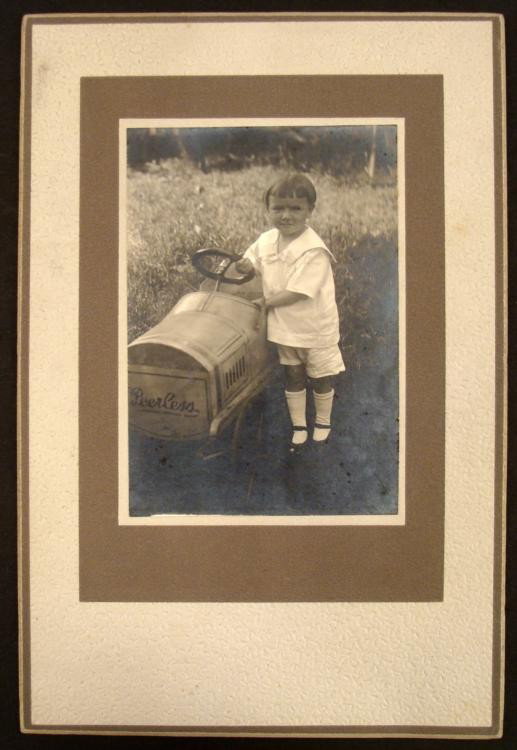 Antique Photo Old Peerless Automobile Toy Pedal Car: This antique photograph shows an old Peerless automobile in a child's version. This terrific pedal car has a the Peerless logo on front, and nicely painted details of the hood and side vents. The youn