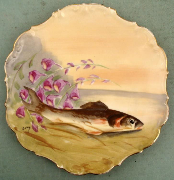 Limoges Antique Hand Painted Fish Wall Plate Signed: This decorative antique Limoges porcelain plate was hand-painted with the image of a fish and flowers. It is signed in the lower left, and has a green Limoges hallmark on the back. The plate design is