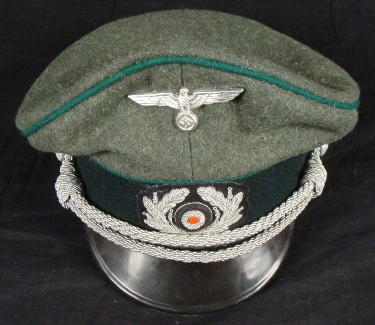 Nazi Army Replica WWII Military Cap: Here is a replica of a WII era Nazi Army cap. It is nicely detailed, in olive wool with green piping, black velvet band, tan silken lining and leather sweatband. It features an eagle and swastika pin,