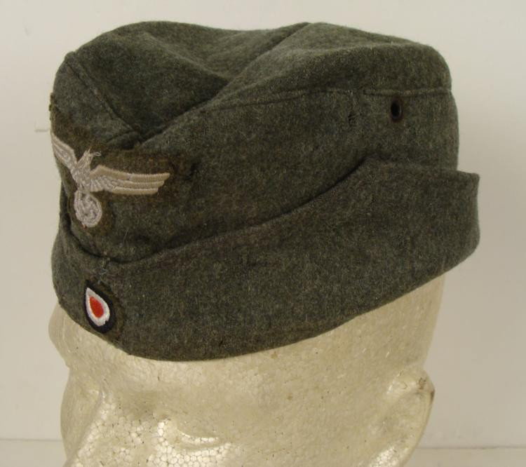 Nazi WWII Replica Cap Prop for Czech Republic: This Nazi cap is a WW II replica, made as a movie prop in the Czech Republic. It is olive wool, with two grommet vents, and eagle and swastika patch. The canvas lining is date stamped 1951, with numbe