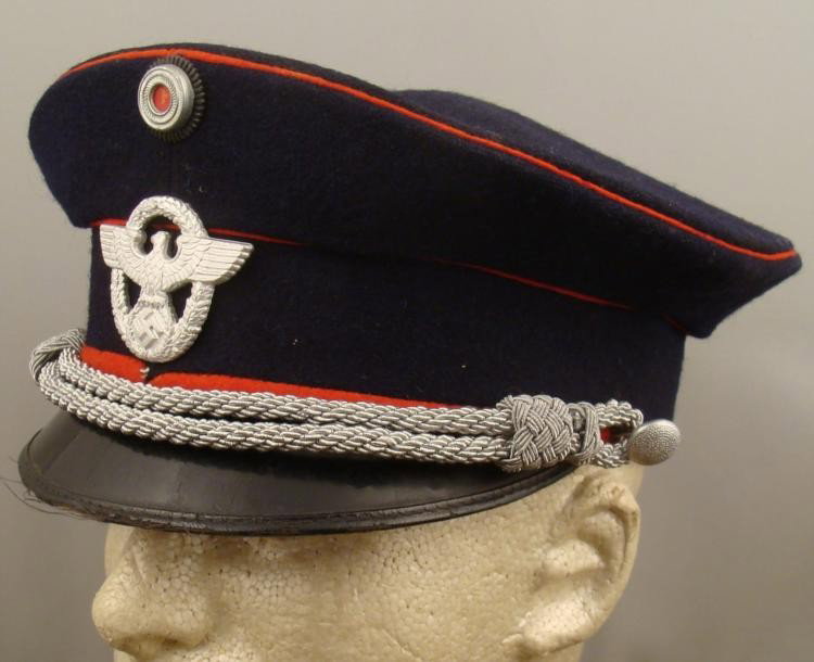 ORIGINAL NAZI WWII FIRE POLICE OFFICER'S VISOR HAT: OFFERED HERE IS AN ORIGINAL NAZI, WWII FIRE POLICE OFFICER'S VISOR HAT. IT HAS A BLUE WOOL BODY WITH RED PIPING. THE VISOR WAS MARKED ON INSIDE BY A MAKER IN SALZBURG AUSTRIA. THE CO