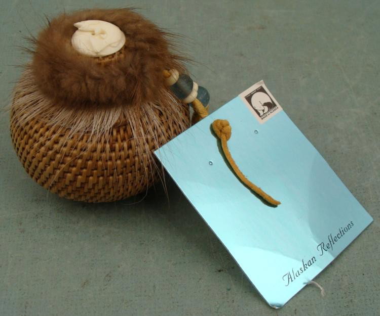 Hand Woven Beaver & Caribou Fur Basket From Alaska: This is a handwoven round spherical basket from Alaska. Its lid is enhanced with carved caribou bone, caribou and beaver fur, and recycled glass and bone beads on a rawhide string. The size is 3". Its