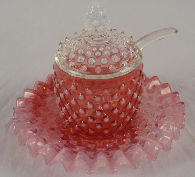 Fenton Cranberry Opalescent Hobnail Jam Set 1940s-50s: This is a Fenton Cranberry Opalescent Jam Set, with hobnail pattern. The four pieces include a jar, lid, plate, and clear glass spoon. * Condition: ExcellentSizes: Jar with the lid is 5 1/2" tall; Dis