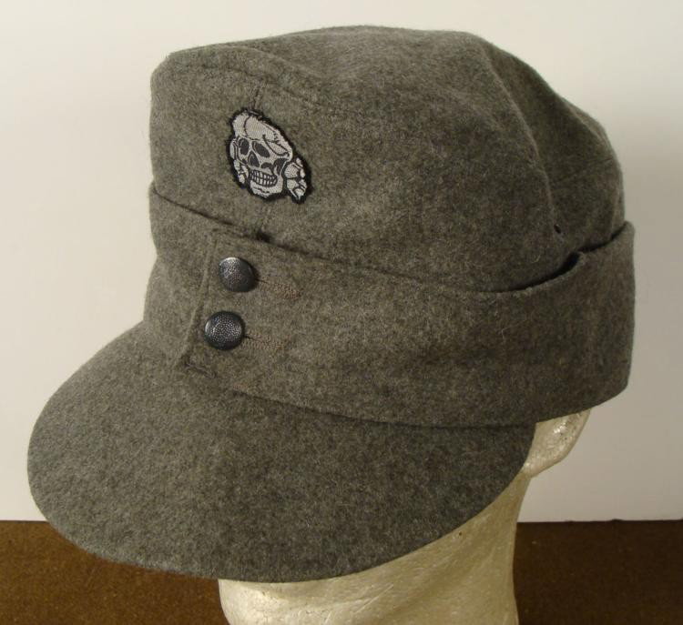 REPRODUCTION SS M-43 CAP DEATH HEAD INSIGINA: THIS IS A REPRODUCTION OF A SS M-43 CAP, DEATH HEAD INSIGNIA. IT IS MADE OUT OF GRAY WOOL AND HAS TWO SEWN PEBBLE BUTTONS IN THE FRONT. * * * *