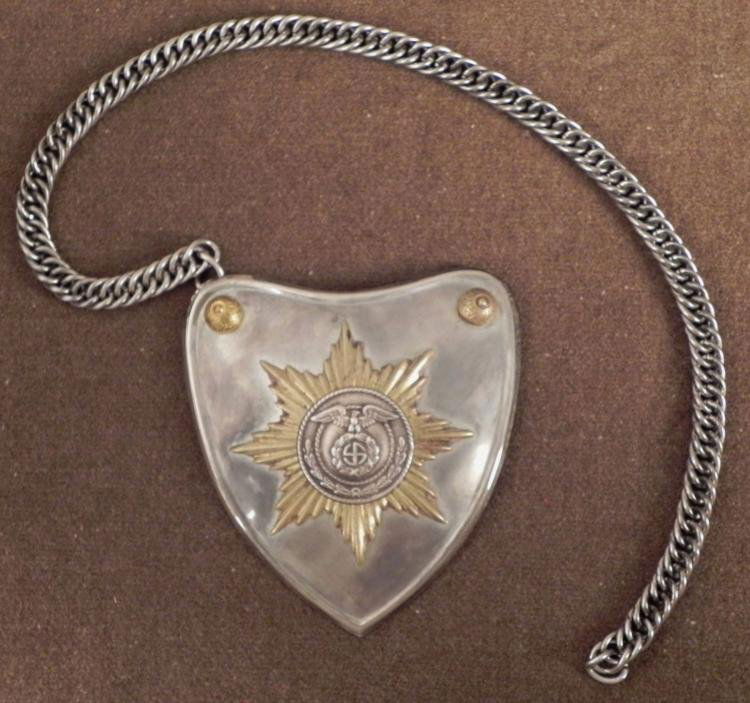 NAZI SS/SA PARADE STANDARTE BEARERS GORGET: THIS IS A NAZI SS/SA PARADE STANDARTE BEARERS GORGET. IT IS HEART SHAPED WITH A SILVER GORGET. THE GORGET HAS A SILVER LINK CHAIN & A GOLD STAR BURST SS/SA INSIGNIA IN THE CENTER. 
