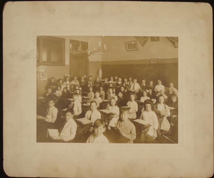 Antique Photograph Old Grade School Classroom Children: This is a class picture from a grammar school from the early 20th century. The children are posed with their books out, rather than just sitting or standing like in most school photos. A "Palmer Metho
