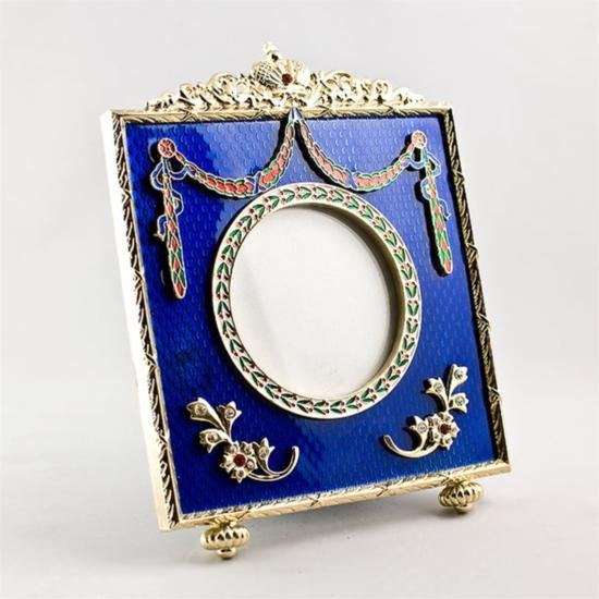 Classic Faberge Picture Frame: Classic Faberge Picture Frame, The Faberge picture frame is in a royal blue guilloche enamel with golden mounted edges. The top of the photo frame is ornamented with a colorful garland falling aro