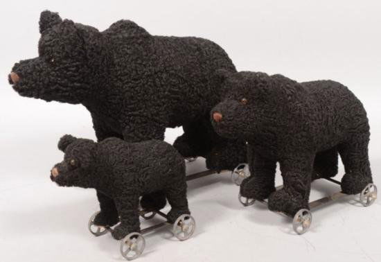 ET0503120168 Three Graduated Toy Black Bear Pull Toys.: Three Graduated Toy Black Bear Pull Toys. Strap iron frame with four cast tin spoked wheels. Bears have a curly lamb coat with brown thread nose and glass eyes. All signed on front paw pads: inM.E. Be