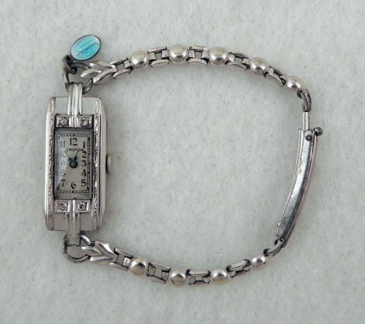 14K White Gold Croton Ladies Vintage Watch: This 14K White Gold Croton Ladies wristwatch has an elegant long style, with decorative bezel and small diamonds. * Dial: White with black numerals and blued steel handsMovement: 17 jewels, unadjusted