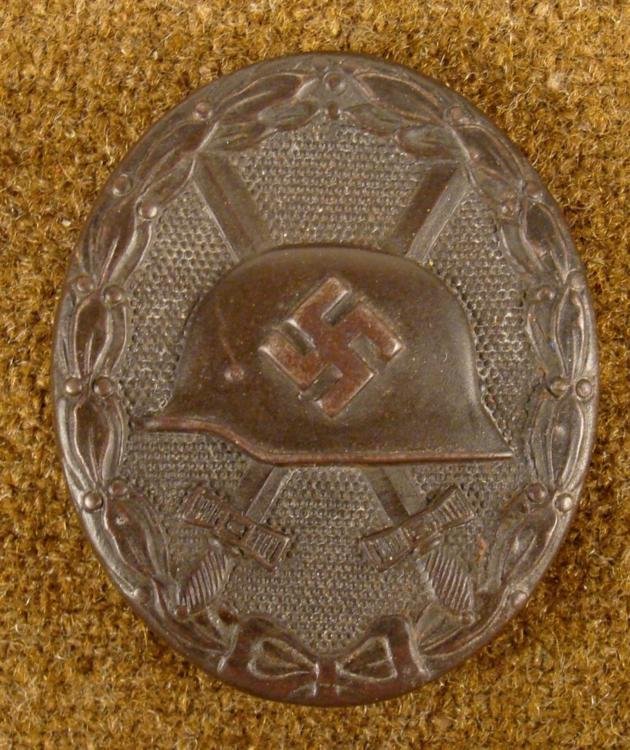 ORIGINAL BLACK NAZI WOUND BADGE: THIS IS AN ORIGINAL BLACK NAZI WOUND BADGE. IT HAS A HELMET WITH A SWASTIKA & CROSSED SWORDS. THIS GREAT WOUND BADGE WAS AWARDED DURING THE WAR TO A WOUNDED NAZI OFFICER. THE BAD