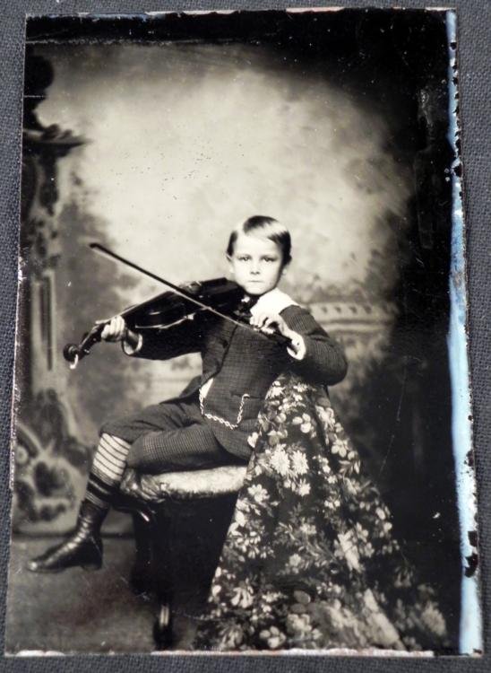 Antique Tintype Photograph Child Boy w/ Violin: This antique tintype photo is a studio portrait of a young boy playing violin, with pocket watch and chain. The size is 2 1/2 x 3 1/2 inches. The condition is very good, with slight dings in the tin.