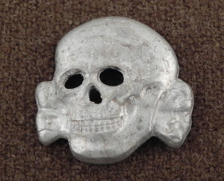 S NAZI VISOR HAT TOTENKOMF SKULL: THIS IS A SS NAZI VISOR HAT TOTENKOMF SKULL. IT IS 1 1/4" LONG AND IS MARKED "RZM SS 360/42" ON THE REVERSE. THERE IS A SINGLE PRONG IN BACK AND SHOWS AGE. *