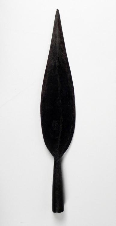 African Antique Broadhead Arrow Spear Tip: This is an old arrow tip from a spear, originating from Africa. The large, broad blade was designed for hunting medium sized game. It is made from iron forged into a flat leaf shape with a short tang.