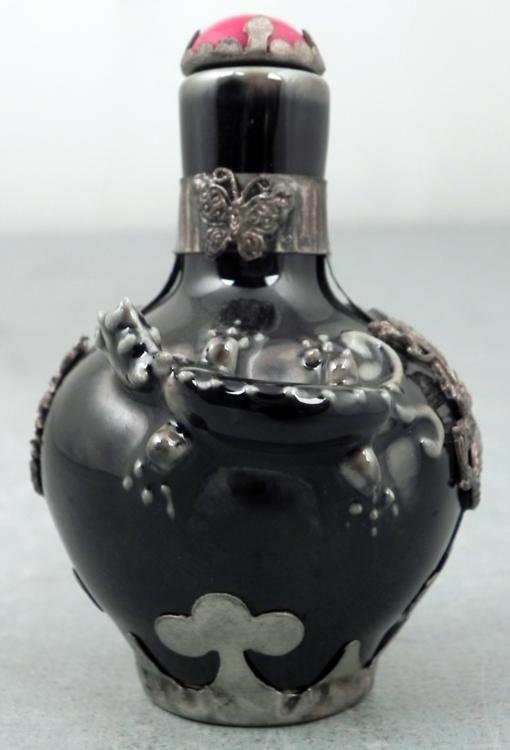 Vintage Black Ceramic Chinese Snuff Bottle w/ Dragons: This is a vintage snuff bottle in ceramic with a black lacquer finish, 3-dimensional dragon figure, and metal overlay depicting dragons and robed figures. The cap has a red stone in a crown-like setti