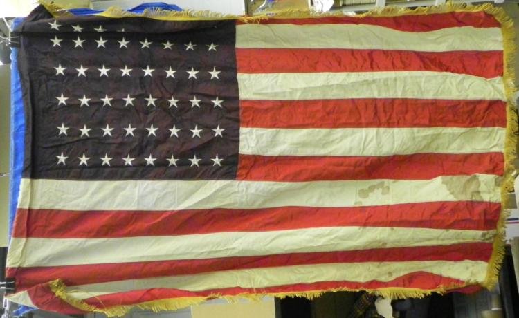 WWII ERA 4X5 FOOT AMERICAN FLAG- 48 STARS: THIS IS A WWII ERA 4X5' AMERICAN FLAG WITH 48 STARS. IT HAS A FRINGE ON THE SIDES AND IS OF A MULTI-PIECE QUALITY CONSTRUCTION. THE FLAG IS MADE OUT OF A NYLON/RAYON TYPE MATERIAL. THERE IS A RO
