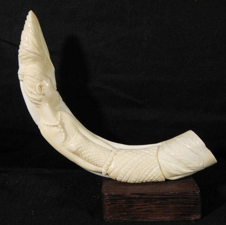 Ivory Polynesian Boars Tusk Carved into Woman: This is a Polynesian ivory boar's tusk carved into the form of a woman. It has nice detail, with textured outfit and necklace. It is 6 inches wide, and is affixed to a wooden stand. Its condition is v