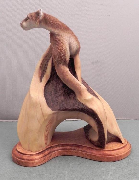 Stepping Out Mill Creek Studios Cougar Cat Sculpture: This cougar or wildcat appears to be rising up right out of a natural wood formation, with its elegantly flowing form, and marvelous detail. This sculpture is titled "Stepping Out", number 63100, and 