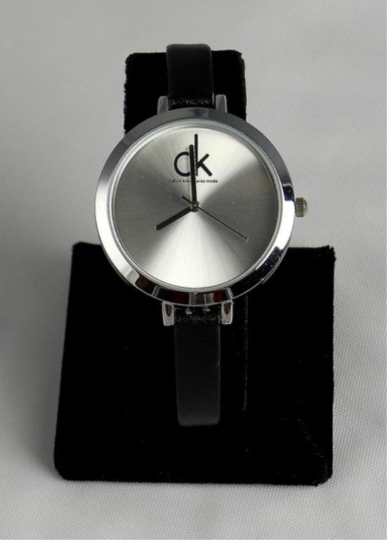 Lady's Hot Leather Watch W/silver Face: Watch Has A Contemporary Stainless Steel Case With Silver Colored Face Inscribed With The Letters Ck For Calvin Klein. The Watch Band Is Black. Watch Has A Quartz Movement.