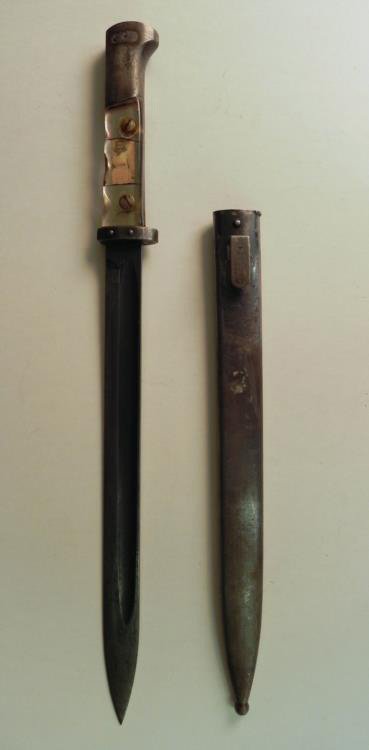 WWII Nazi Trench Art Bayonet: Available is a WWII Nazi Trench Art Bayonet. This bayonet was converted to trench art with the photograph of the Nazi soldier's loved one, cleverly embedded in the handle of the bayonet. The bayo