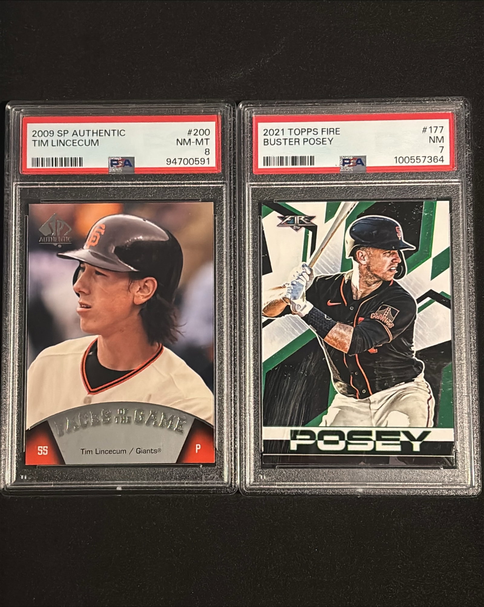 Giants Legends Duo Lot - 2009 SP Authentic Tim Lincecum PSA 8+2021 Topps Fire Buster Posey PSA 7: Premium two-card graded lot featuring two San Francisco Giants all-time greats: (1) 2009 SP Authentic #200 Tim Lincecum "Faces of the Game" PSA 8 NM-MT. Lincecum is a Hall of Fame-caliber pitcher, 2-t