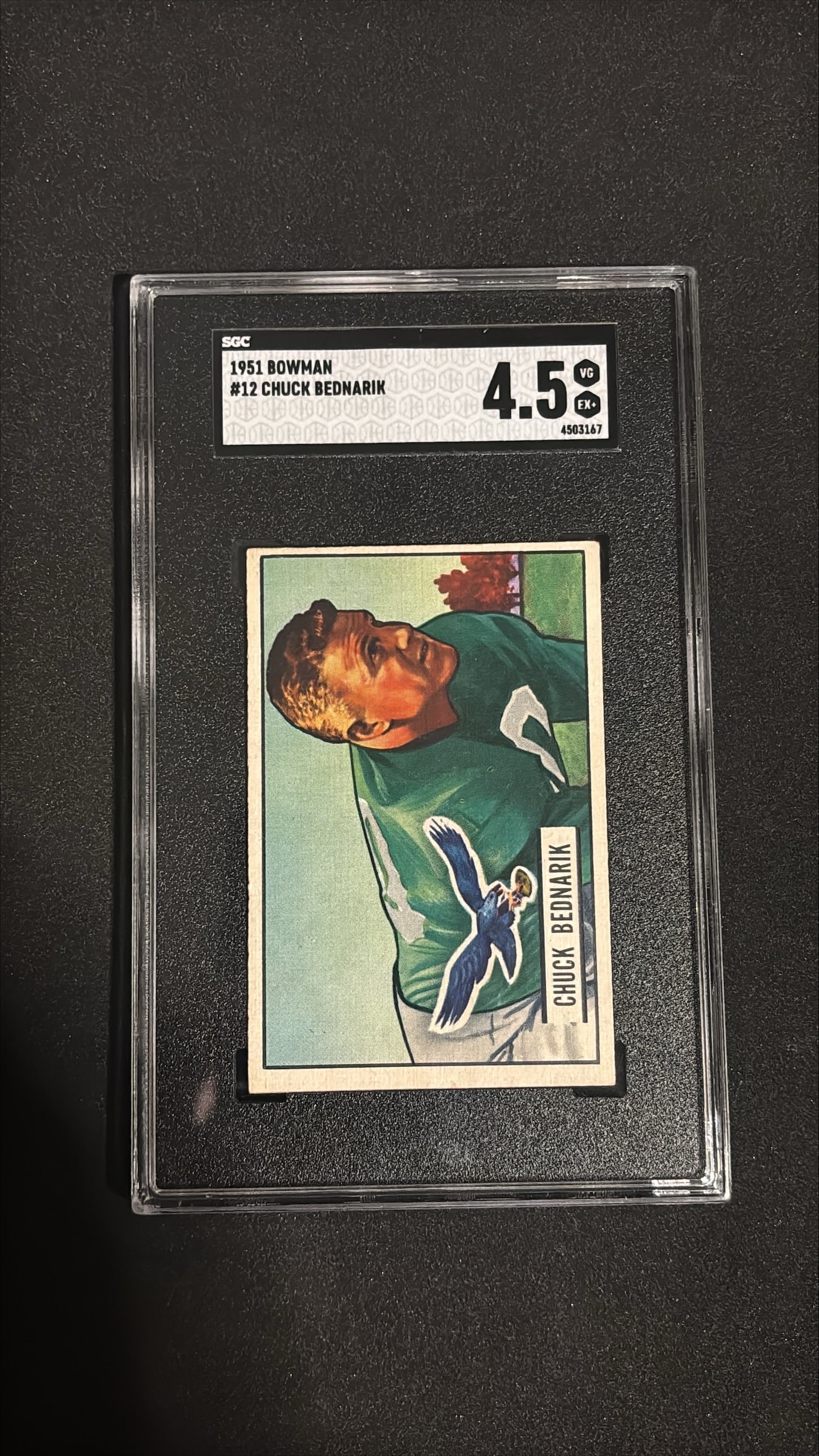 1951 Bowman #12 - Chuck Bednarik SGC 4.5: Vintage 1951 Bowman football card of Hall of Famer Chuck Bednarik, Philadelphia Eagles center. SGC graded 4.5. Classic colorized design typical of early 1950s Bowman football cards. Bednarik is one of