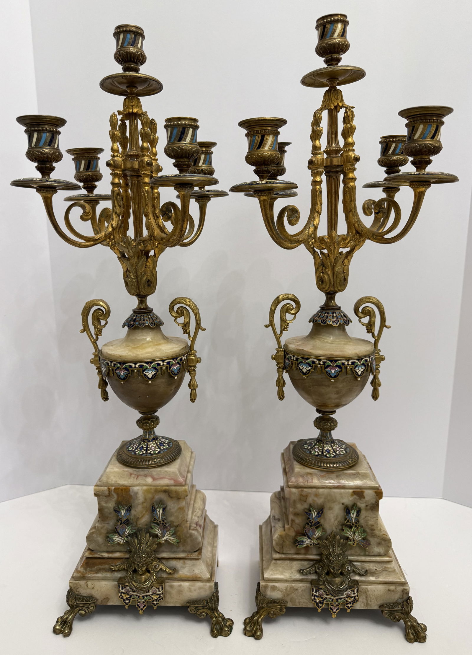 Large Pair of French Antique Champleve Enamel and Gilt Bronze Candelabra on Onyx Base: A magnificent large commanding pair of late 19th-century French gilt bronze and champleve enamel candelabra, each fitted with five candle lights and raised on richly veined onyx plinths. The urn-form